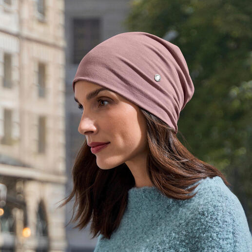 Bambus-Beanie in rosa, getragen von einer Frau in einem blauen Pullover.