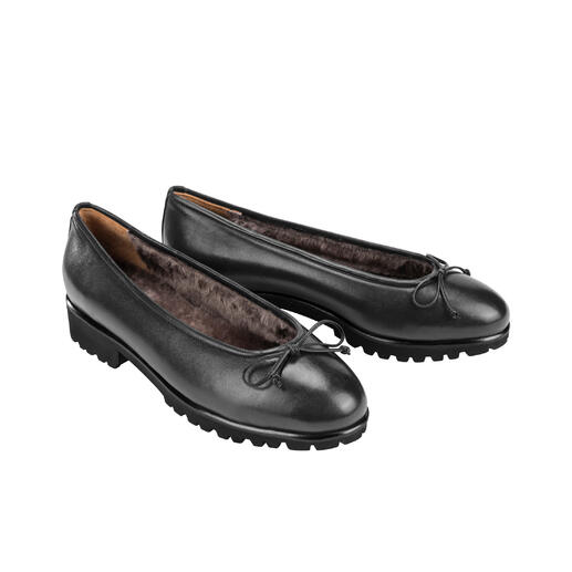 Zwei schwarz Lammfell-Ballerinas nebeneinander auf hellem Hintergrund.
