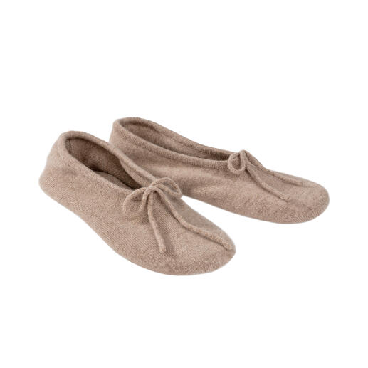 Zwei Kaschmir-Reisehausschuhe in hellem beige nebeneinander.