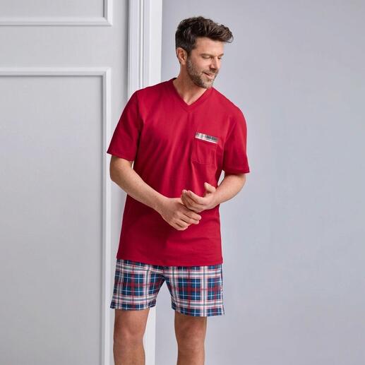Mann trägt einem roten Pyjama mit karierten Shorts in Blau und Weiß.
