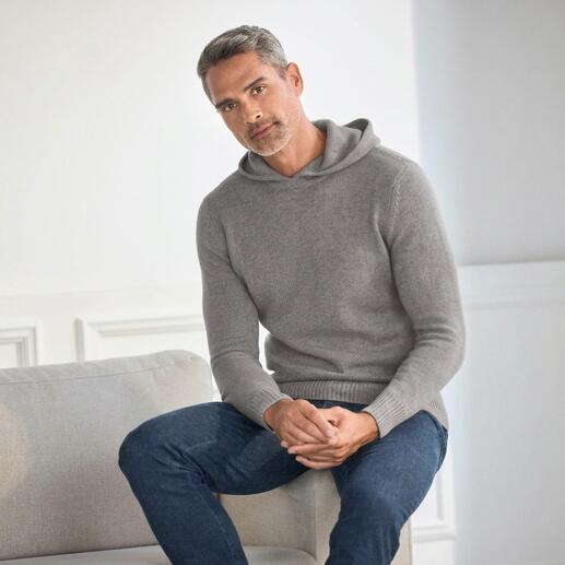 Mann in grauem Boiled Cashmere H-Hoodie sitzt auf einem Sessel