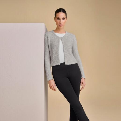 Frau in grauem Metallic-Bolero über weißem Oberteil