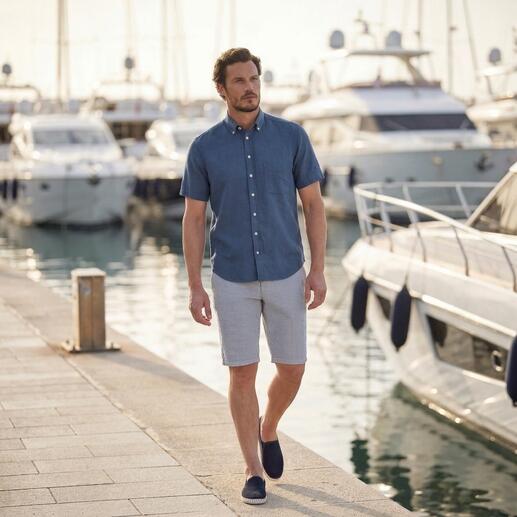 Mann in marineblauem BDO-Shirt und Shorts läuft am Hafen entlang.