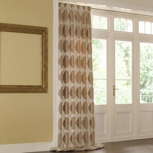 Vorhang Empress mit trendigem Muster in Beige, hängt an einem Fenster.