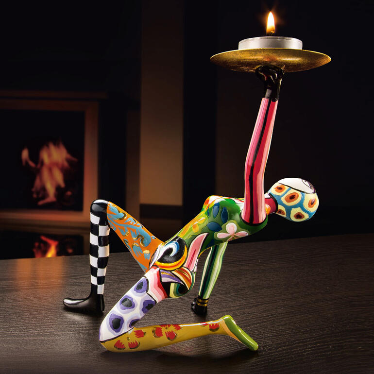 Bunte Skulptur von Tom mit einer Kerze auf einem Tisch.