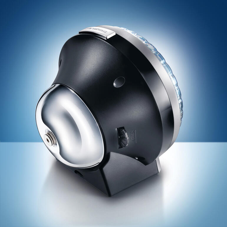 Die klassische Glocke auf der Rückseite. Eine schöne Erinnerung an längst vergessen geglaubte Tage … Stylischer analoger Wecker mit beleuchtetem Ziffernblatt auf blauem Hintergrund.
