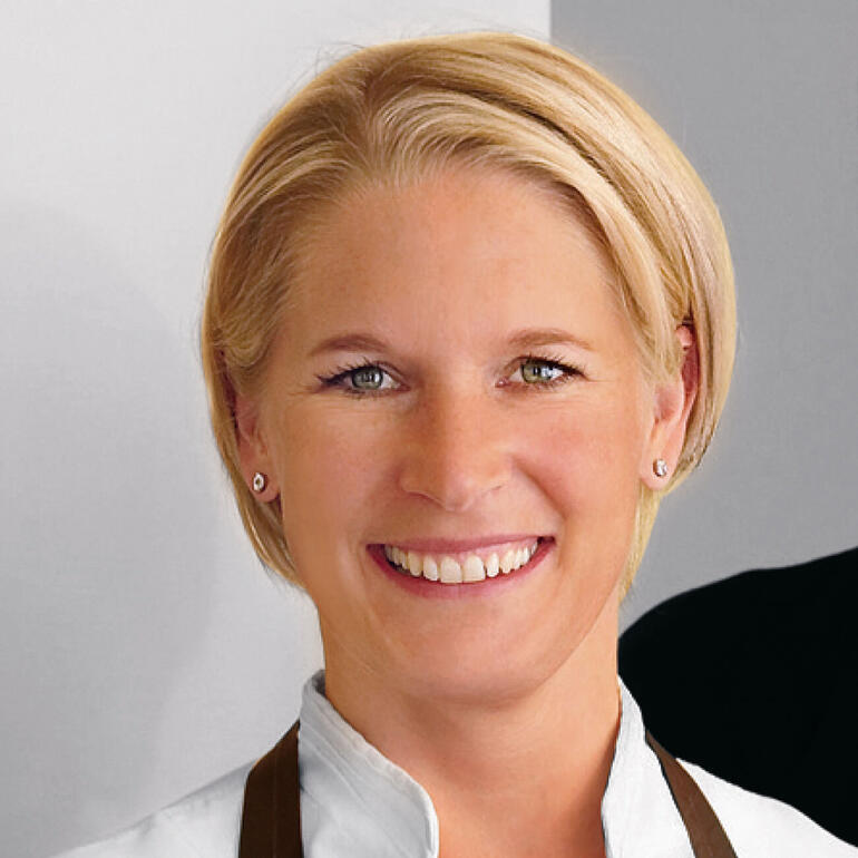 Fernsehköchin Cornelia Poletto hat bei der Entwicklung dieses Profi- Porzellans mitgewirkt. Frau mit blonden Haaren lächelt vor neutralem Hintergrund.