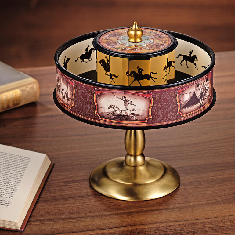 Praxinoskop auf einem Tisch mit einem Buch daneben