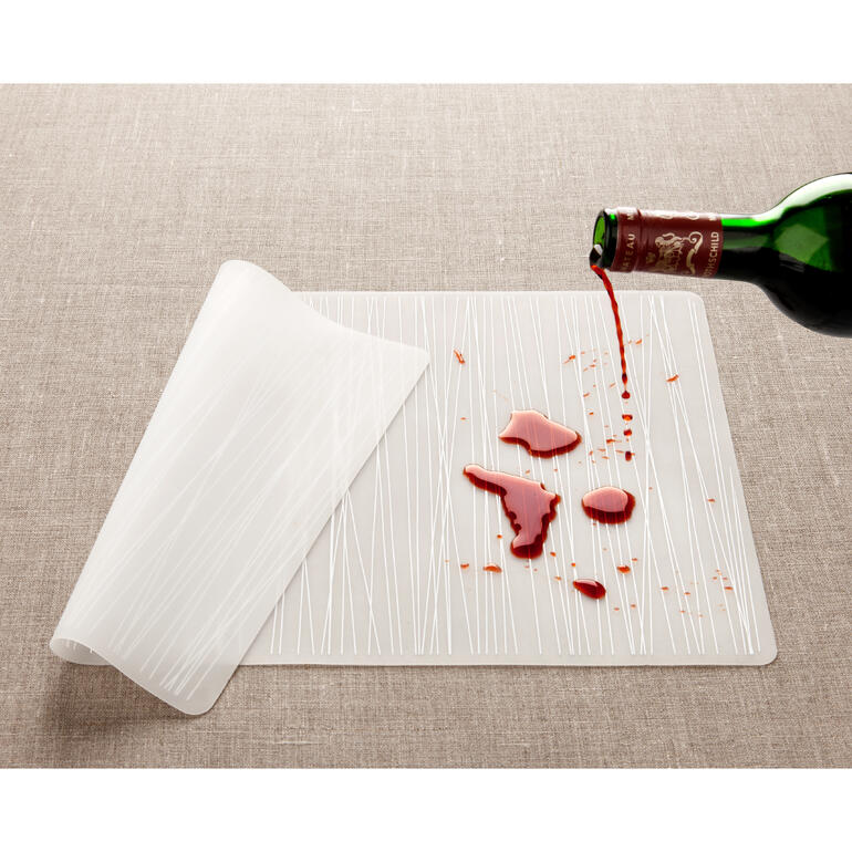 Selbst farbintensive Flüssigkeiten lassen keine Spuren zurück. Silikon-Tischset mit verschüttetem Rotwein und Reinigungshinweisen.