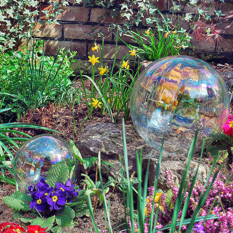 Zwei Seifenblasen im blühenden Garten mit bunten Blumen