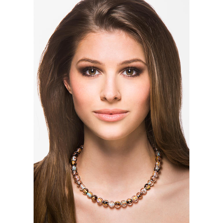 Murano-Perlencollier Modell trägt ein Murano-Perlencollier und lächelt.