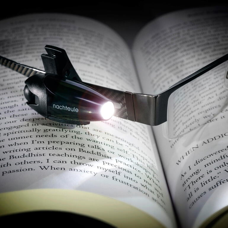 Clip-Leuchte mit eingebautem LED-Licht über einem offenen Buch.