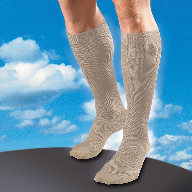 Beige Beige Stütz-Kniestrümpfe an Beinen vor blauem Himmel