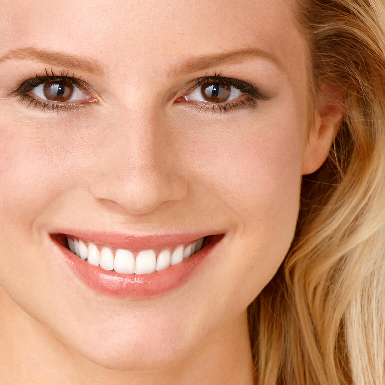 Whitening-Zahncreme Diamond Glow, 75 ml Lächelnde Frau mit strahlend weißen Zähnen