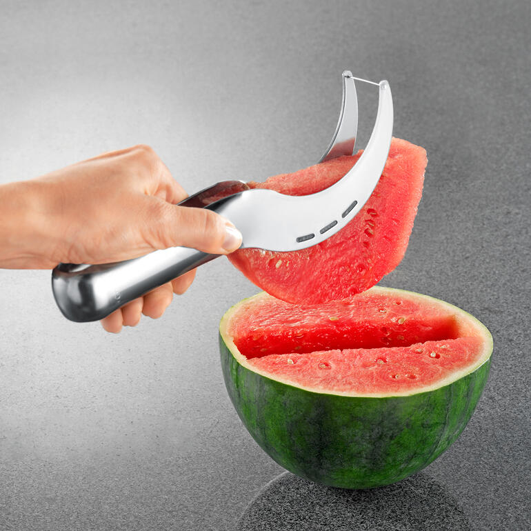 Melonenschneider Melonenschneider hebt ein Stück aus einer halbierten Wassermelone.