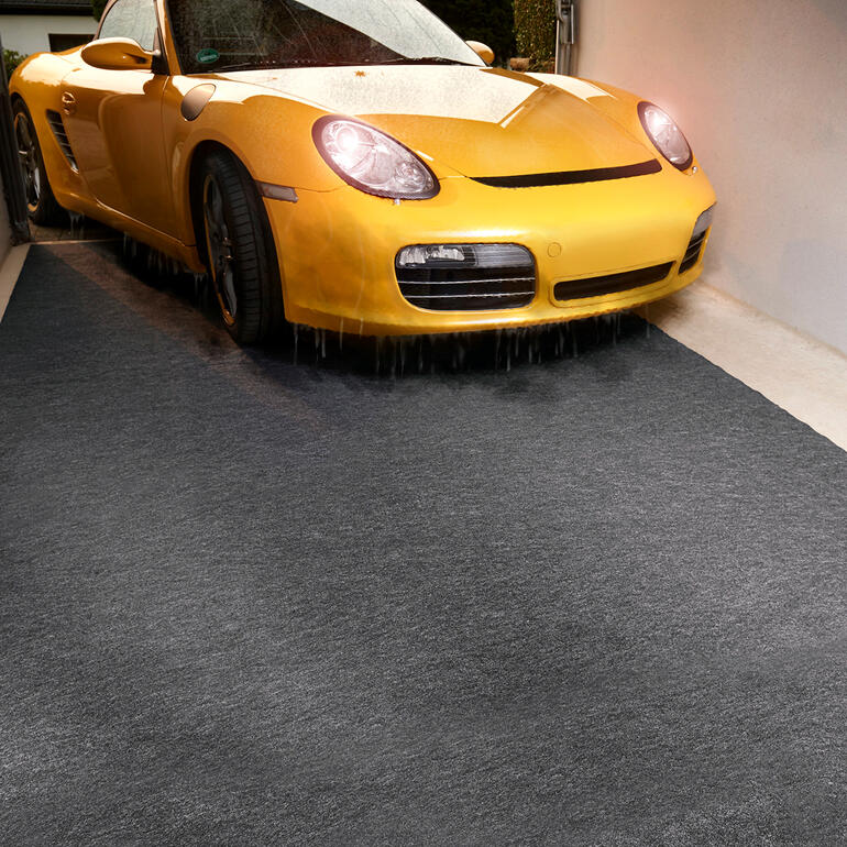 Gelber Sportwagen auf einer mattschwarzen Garage.