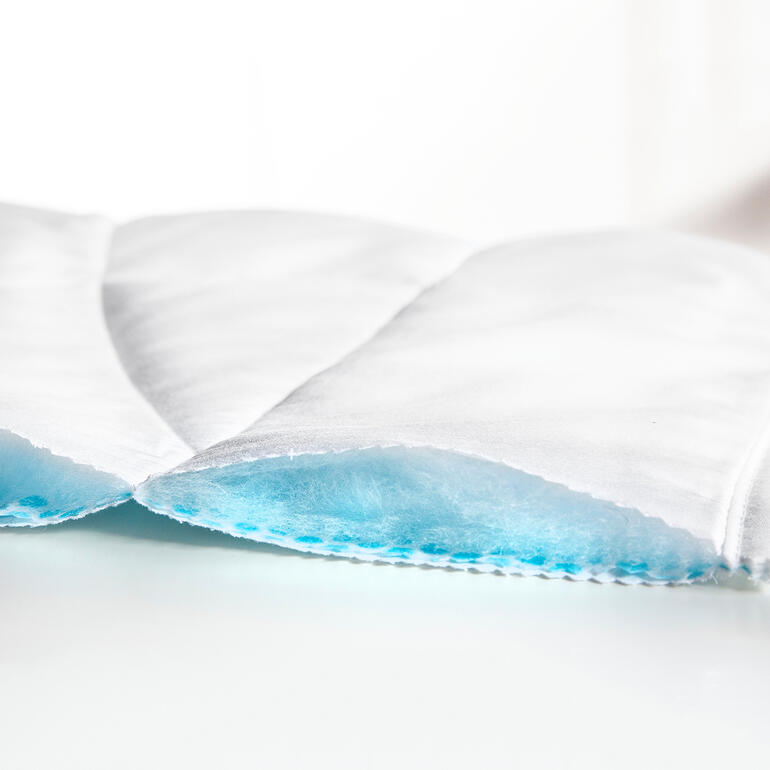 Bezug aus Baumwoll-Satin, Tencel®-Füllung, Vliesseite, PCM-Mikrokapseln Detailansicht einer weißen Sommerdecke.