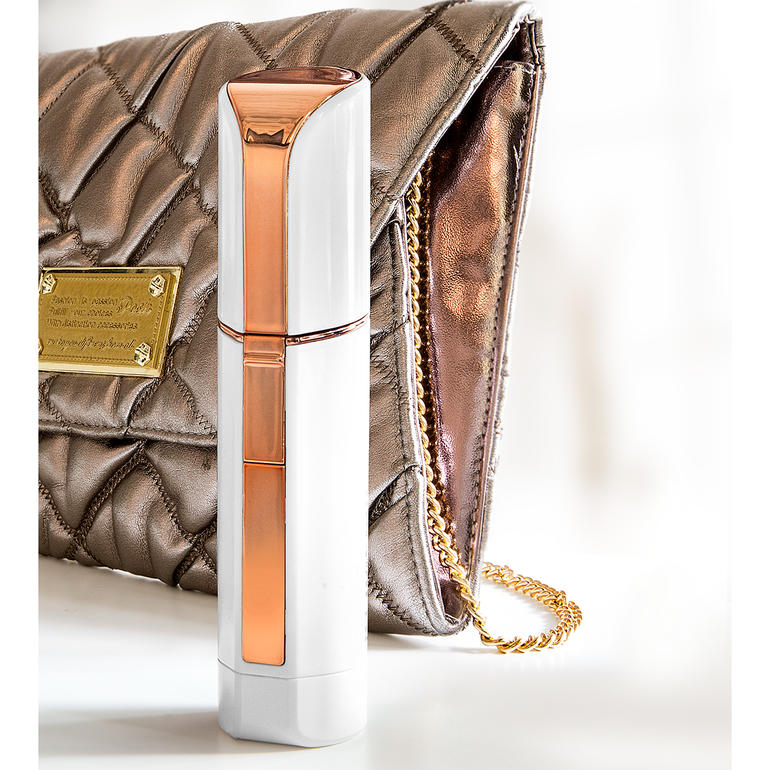 Im diskreten Lipstick-Design ideal für die Handtasche. Gesichtsrasierer Roxy Pocket Shaver neben einer modischen Handtasche.