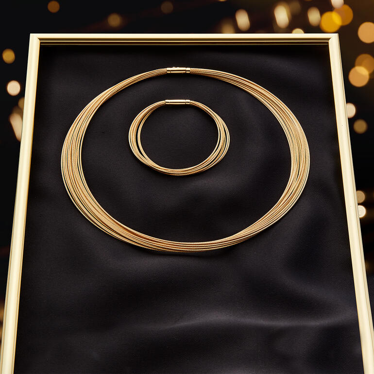 Gold-Armband und Gold-Collier auf schwarzem Untergrund