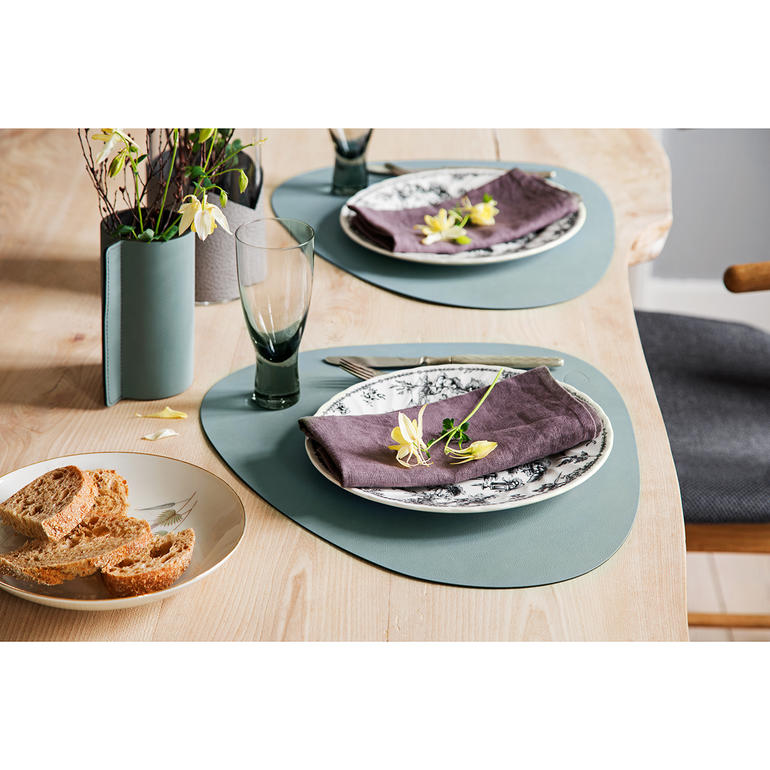 Salbeigrün Tischgedeck mit salbeigrünem Platzdeckchen und Geschirr.