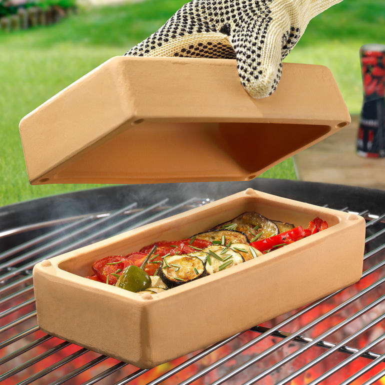 RÖMERTOPF® BBQ Brick mit Gemüse auf dem Grill, Deckel wird angehoben.