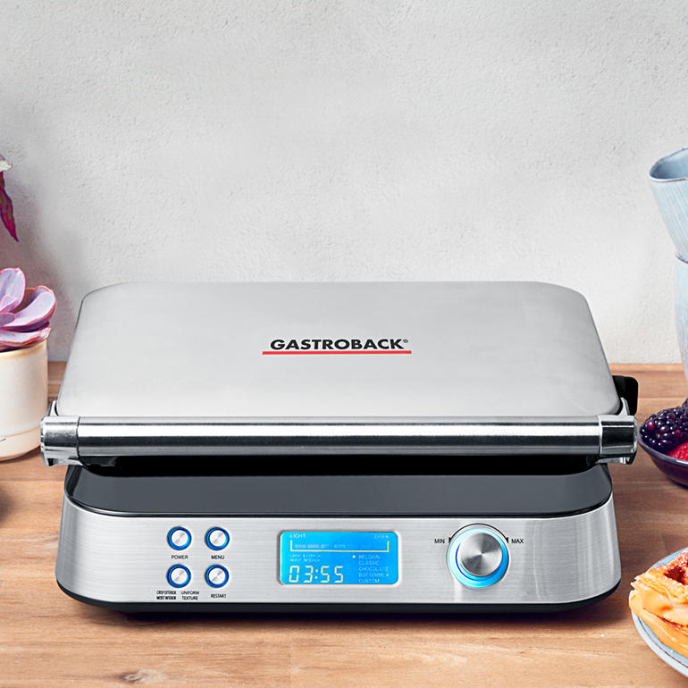 Gastroback Waffelautomat Advanced Control Gastroback Waffelautomat mit geschlossenem Deckel auf einer Holzplatte.
