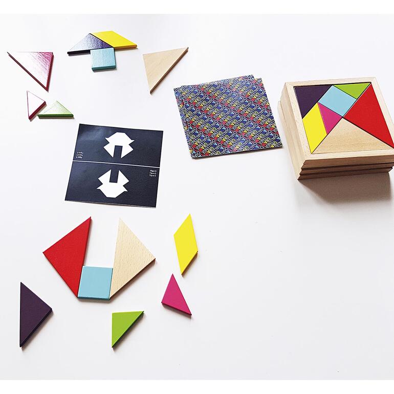 Tangram Challenge Tangram Puzzle-Teile liegen auf einem Tisch mit Vorlagenkarten.