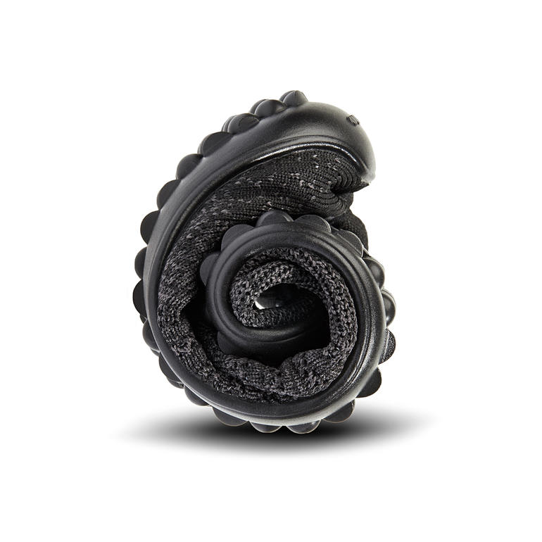 Nur 8 mm dünn und extrem biegsam: die Noppensohle aus Lifolit®. Gerollte schwarze Barfuß-leguano® Knit-Sneaker, kompakt zusammengelegt.