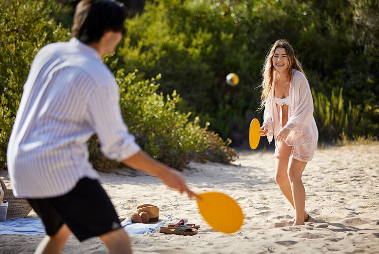 Paar am Strand, spielt handgefertigtes Beachball-Spiel