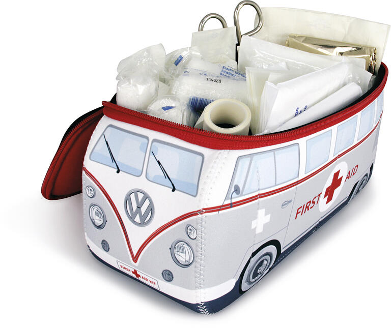 Enthält die komplette Erste-Hilfe-Ausstattung nach DIN-Norm: Verbandszeug, Tape, Schere, Feuchttücher, Schutz-Handschuhe, Rettungsdecke, … VW-Erste Hilfe Set geöffnet mit Inhalt auf weißem Hintergrund.