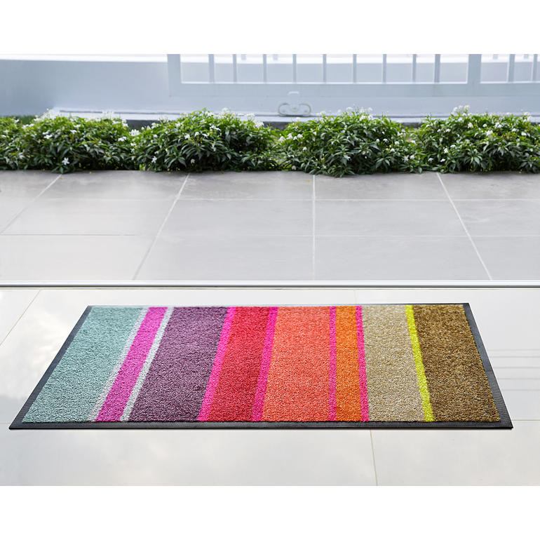 Bunte Design-Fußmatte mit Streifen vor einer Glasfläche