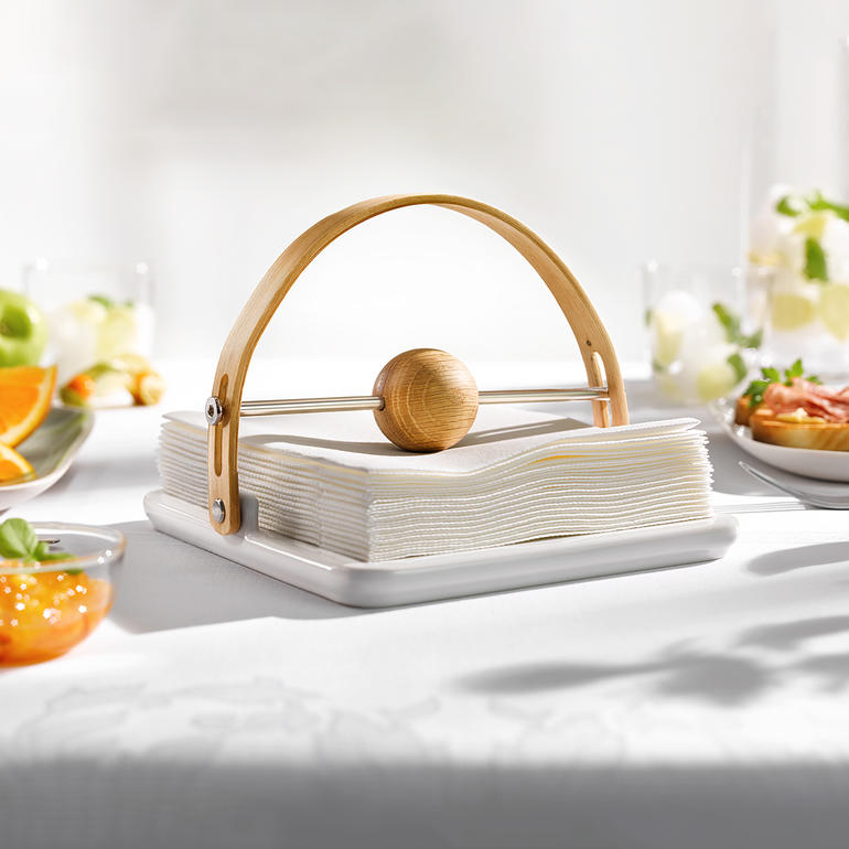 Design-Serviettenhalter aus Porzellan mit hölzernem Haltebogen.