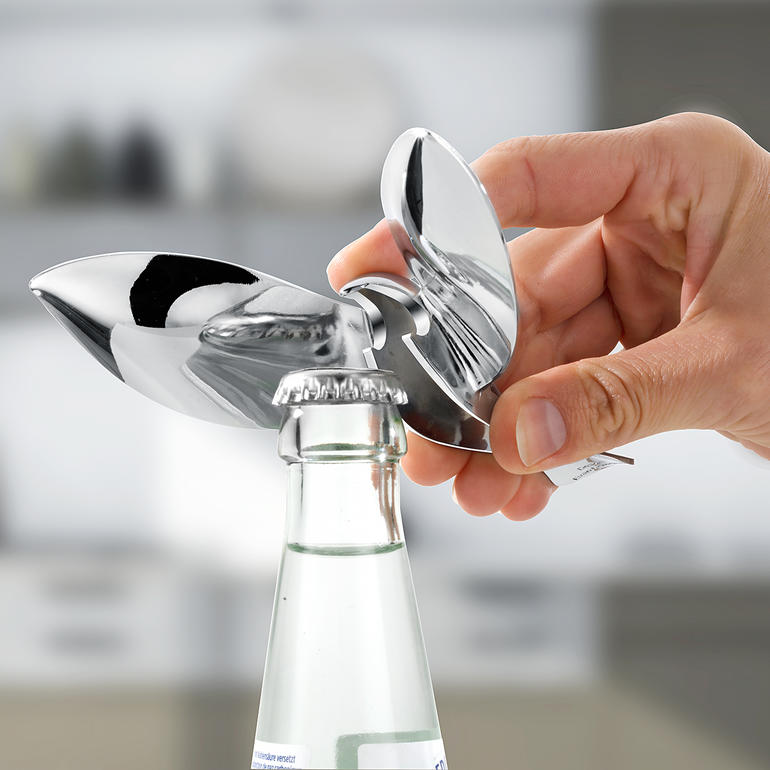 Design-Kapselheber Tipsy Hand, die den Design-Kapselheber Tipsy benutzt, um eine Flasche zu öffnen