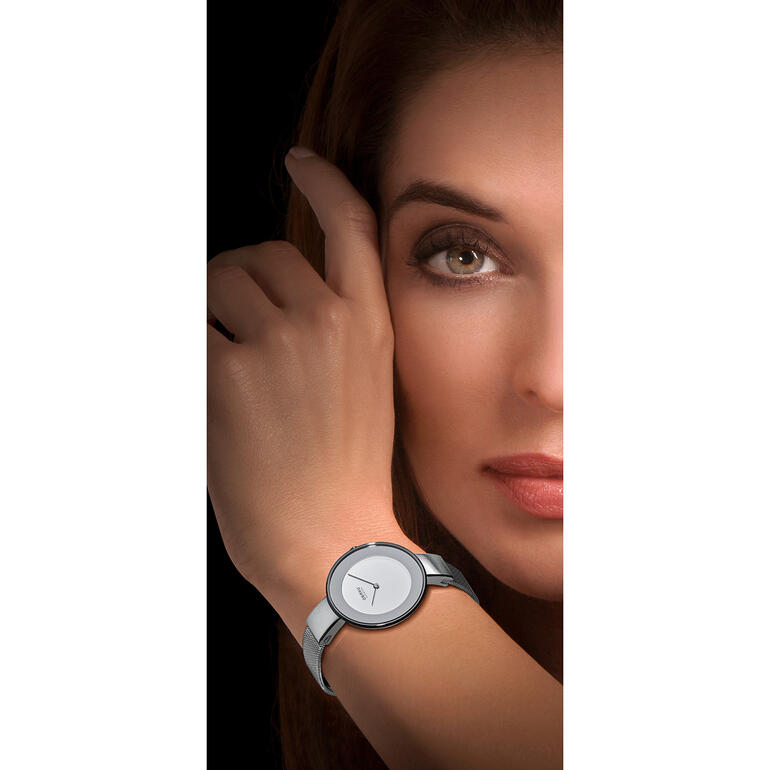 Milanaise-Armbanduhr Frau trägt eine Milanaise-Armbanduhr und schaut zur Kamera.
