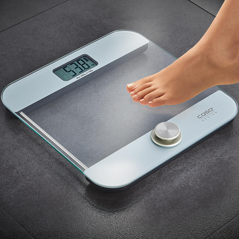 Batterielose Personenwaage mit Fuß auf einer Fläche.