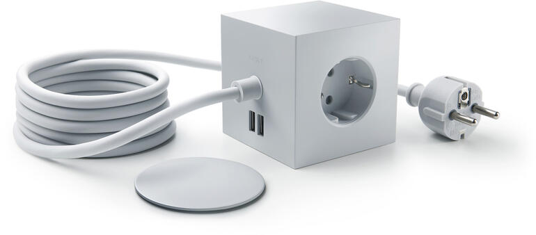 Hellgrau Hellgraue Design-Steckdosenwürfel mit Kabel und Stecker auf einem Tisch.