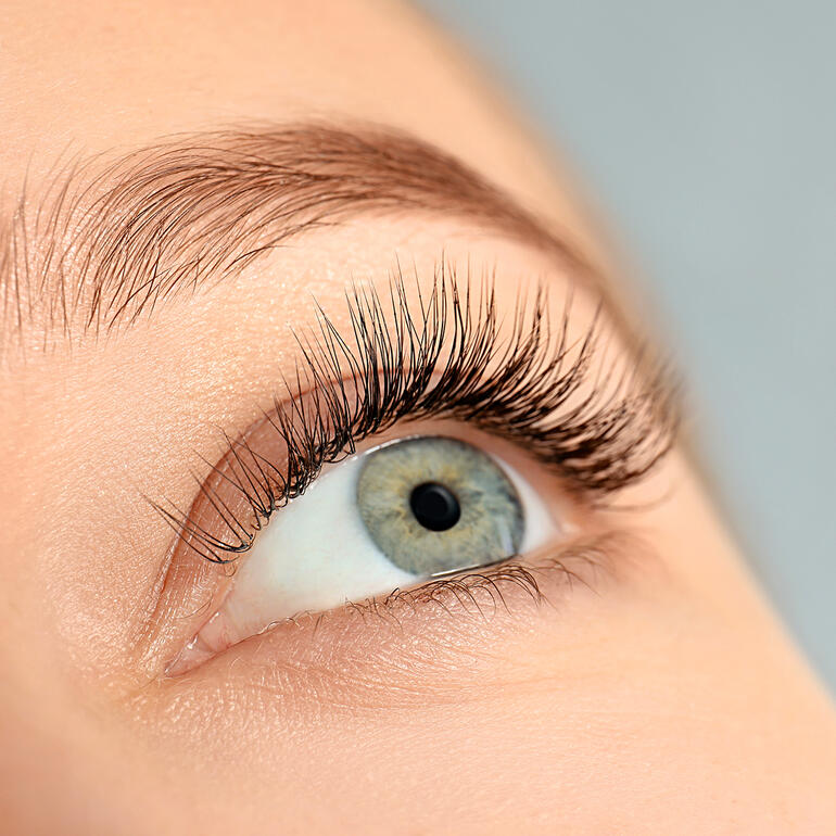 CILAMOUR RAPIDE Wimpern-Serum Nahaufnahme eines Auges mit langen Wimpern, die durch Wimpernserum gepflegt aussehen.