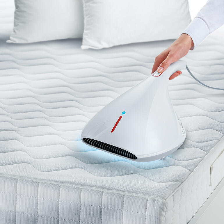 UV-C-Hygienesauger wird über eine Matratze hinweggeführt, um die Oberfläche zu desinfizieren.