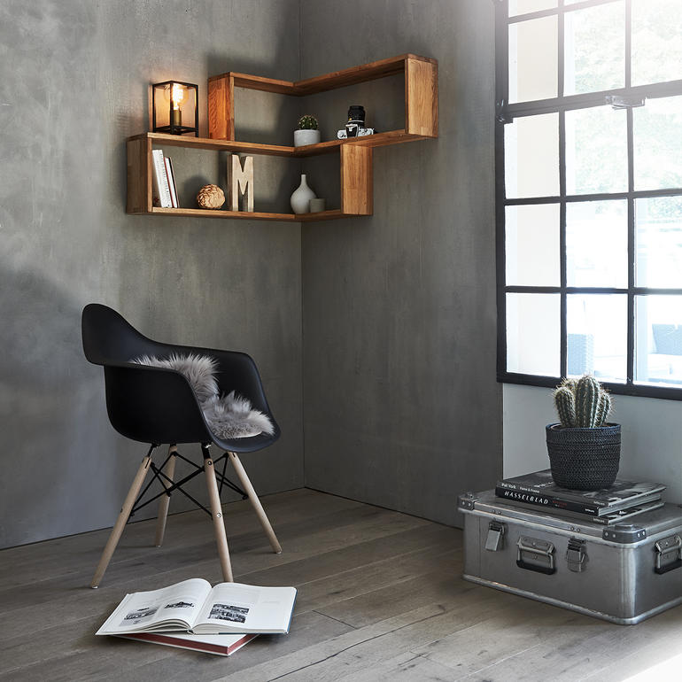 Wand-Eckregal aus Holz mit dekorativen Objekten und einer schwarzen Stuhl in einem Raum.
