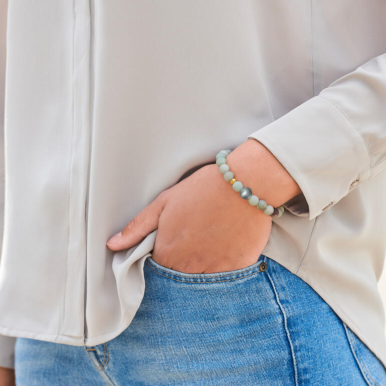 Das elegante Edel-Armband kombinieren Sie zu jedem Look, rund um die Uhr. Nahaufnahme eines Amazonit-Armbands am Handgelenk einer Frau
