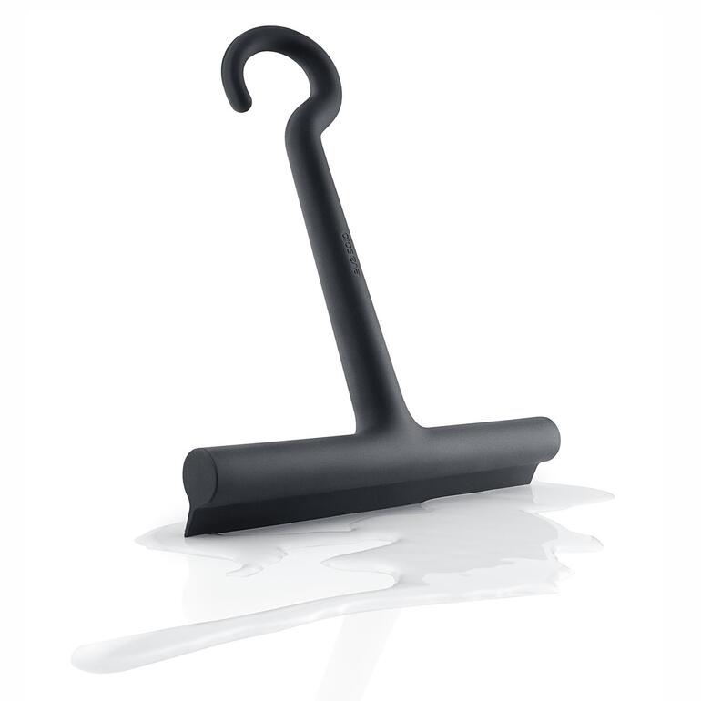 Design-Silikon-Duschabzieher auf einer weißen Fläche mit Wasserflecken.