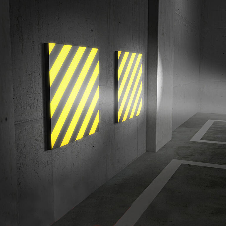 Einfallendes Licht reflektiert äußerst klar auf den gelb-schwarzen Streifen - ein deutliches Plus für mehr Sicherheit beim Einparken. Zwei Garagenwand-Polster mit gelb-schwarzen Streifen an einer Wand.