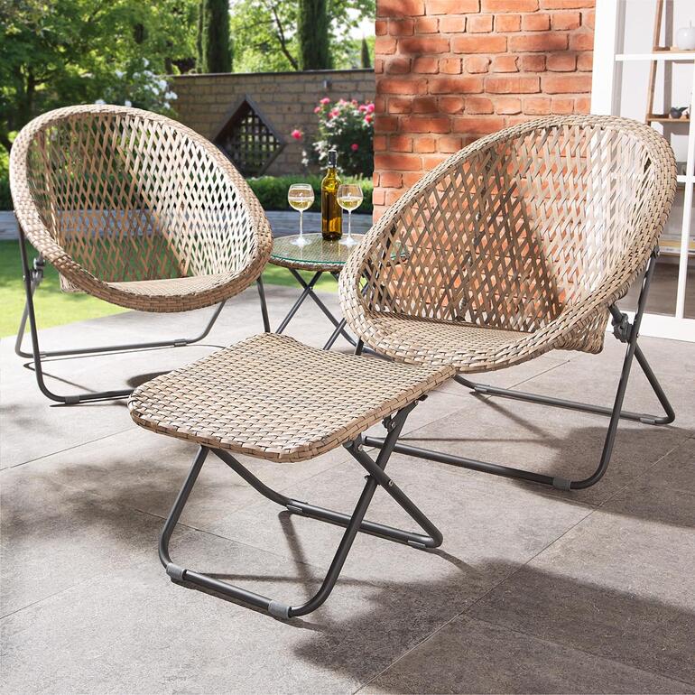Jetzt neu: der passende Fußhocker zum Mitbestellen. Zwei faltbare Loungesessel und ein Tisch auf einer Terrasse.