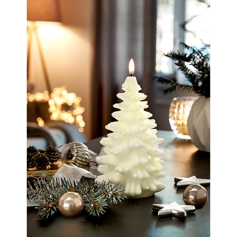 Elfenbein Elfenbeinfarbene LED-Kerze in Tannenbaum-Form, dekoriert auf einem Tisch.