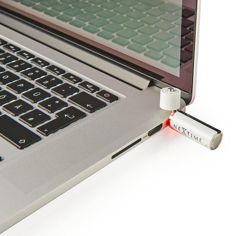 Einfach am USB-Port aufladbar – ohne Ladegerät, ohne Kabel. USB-aufladbare Batterie, die in einen Laptop gesteckt wird, mit rotem Licht.