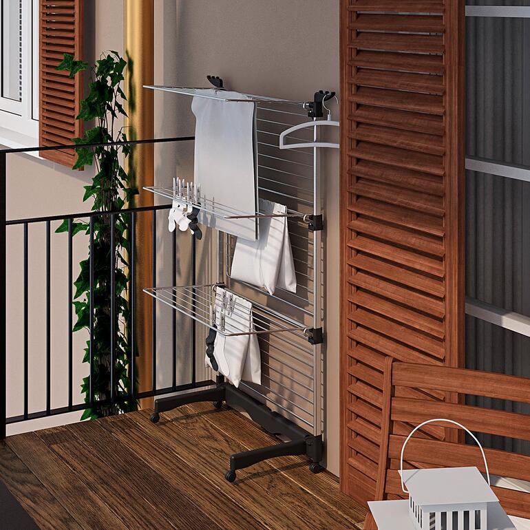 Flexibler Turmwäscheständer auf Balkon mit Laken und Handtüchern.