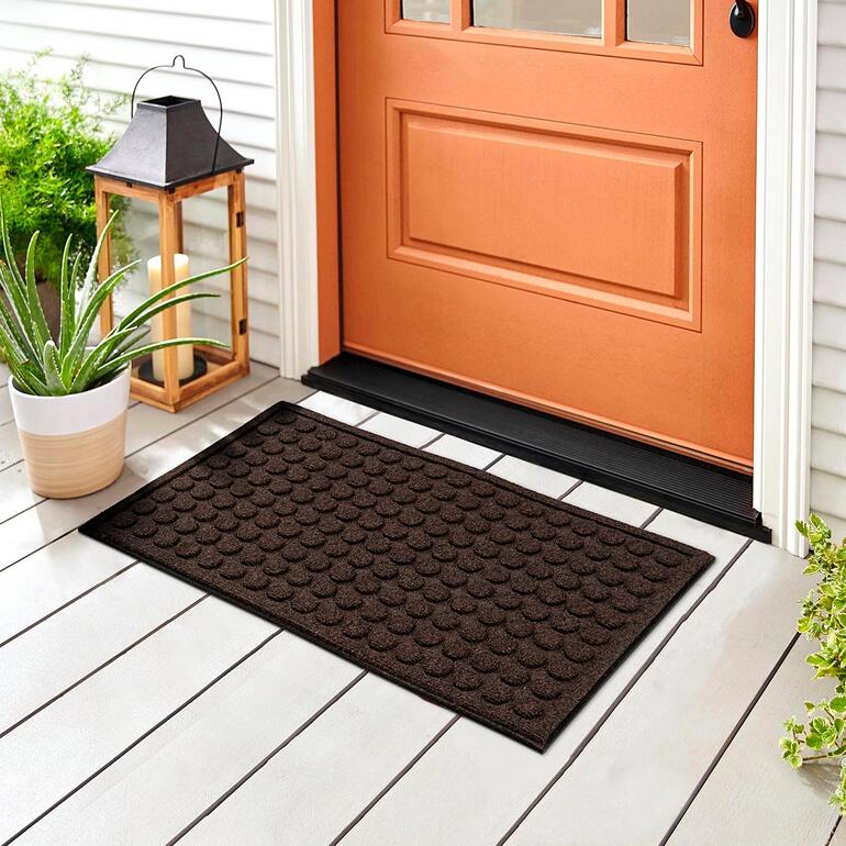 Halbrunde Fußmatte aus recyceltem Gummi in braun, ideal für den Eingangsbereich.