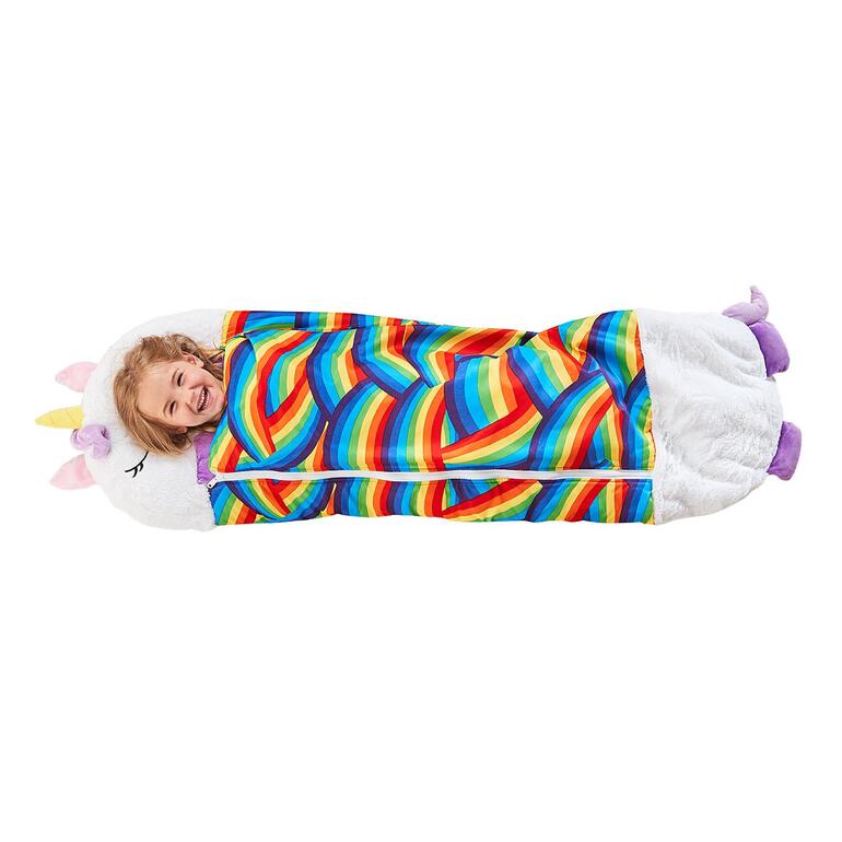 Einhorn-Plüschkissen mit Regenbogen-Schlafsack. Mädchen lächelt in buntem Einhorn-Kuschelschlafsack mit Regenbogenfarben.