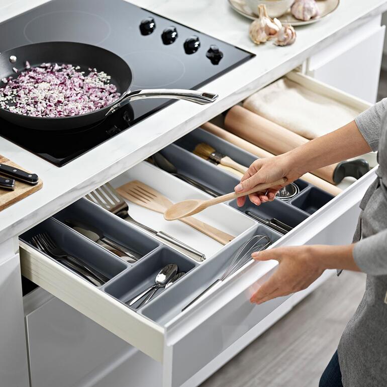 Modularer Schubladen-Organizer mit verschiedenen Fächern in einer Küchenszene.