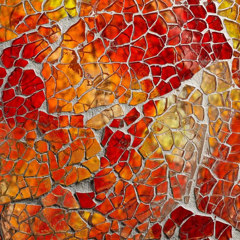Auch bei Tag ein dekorativer Blickfang. Farbenfrohe Glasstückchen in rot und orange, für die Gartenkugel.